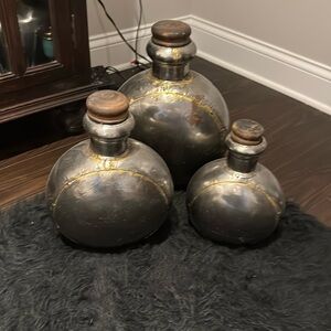 3 metal, distressed canisters with tops for decorative use.